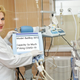 A medical sales rep slaps top of GM prototype ventilator, emphasizing its key features
